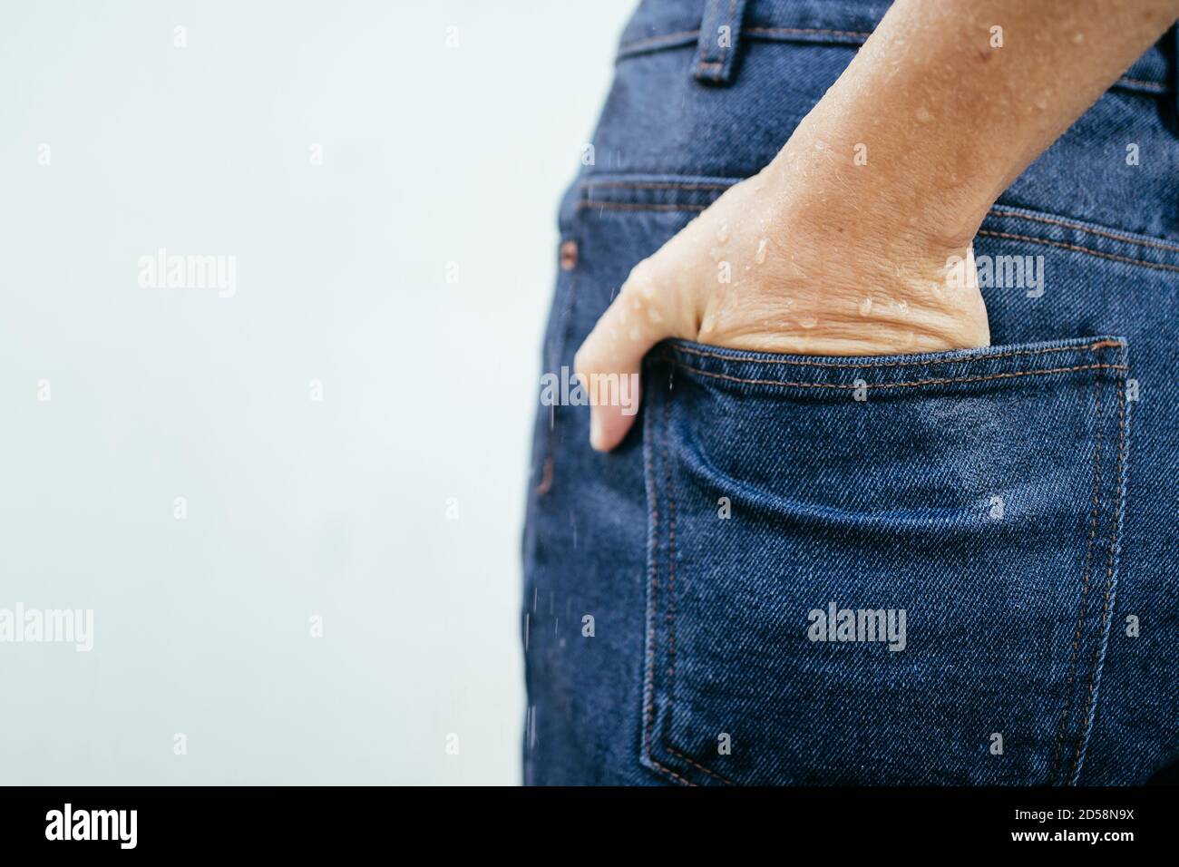 Nahaufnahme der nassen Hand einer Frau in ihrer Jeans-Tasche Stockfoto