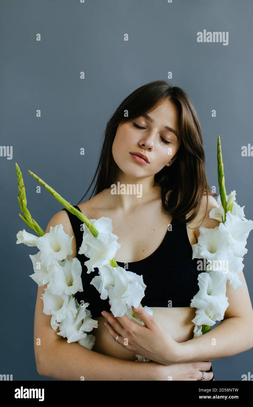 Porträt einer schönen Frau mit weißen Gladioli-Blumen Stockfoto
