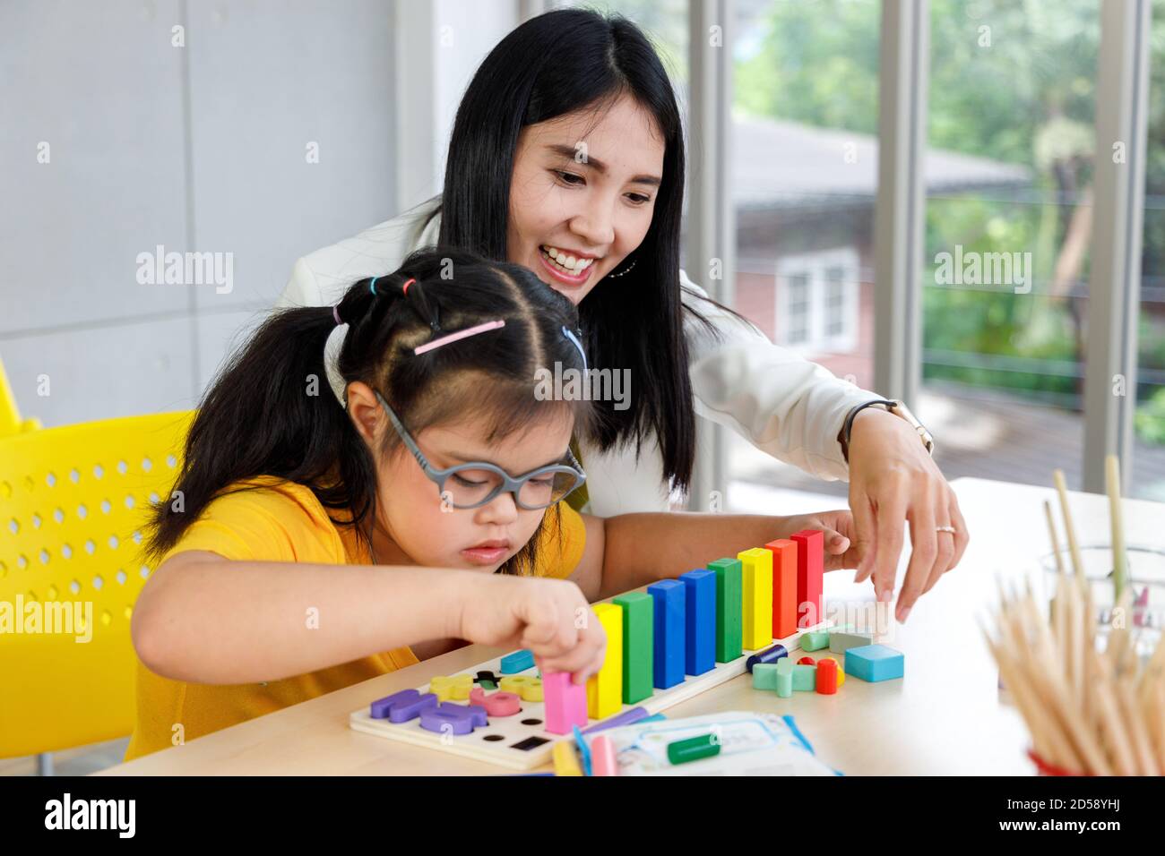 Asiatische Mädchen mit Down-Syndrom spielen Puzzle-Spielzeug mit ihrem  Lehrer im Klassenzimmer Stockfotografie - Alamy