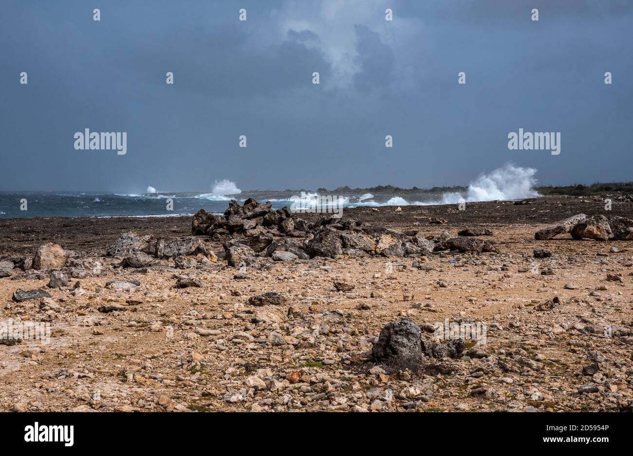 Die zerklüftete Küste mit hohen Wellen und dunklen Wolken Boka Onima auf Bonaire Stockfoto