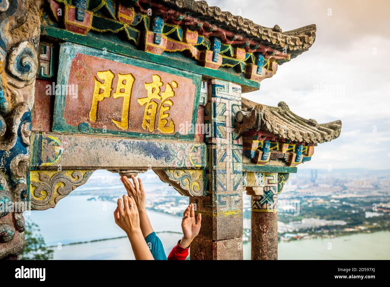 Das Drachentor oder Longmen von West Hill mit Menschen berühren es für viel Glück in Kunming Yunnan China (Übersetzung: Drachentor) Stockfoto