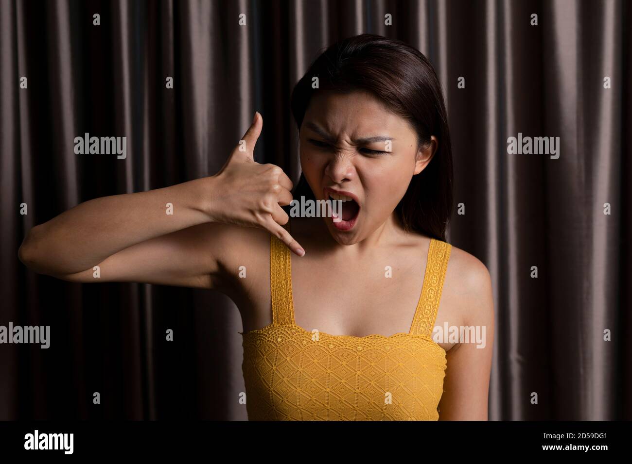 Porträt einer Frau vor einem Vorhang machen Ein Rufzeichen Stockfoto