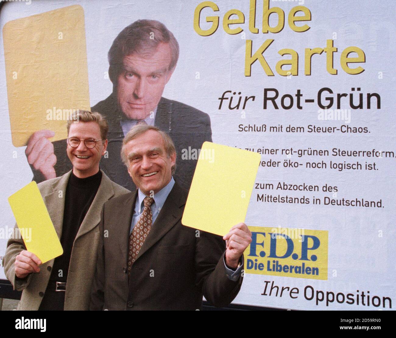 Der Generalsekretär der Freien Demokratischen Partei, Guido Westerwelle (L), und Helmut Haussmann (R), ein ehemaliger Bundeswirtschaftsminister, zeigen gelbe Karten, als sie im März 15 vor dem Bonner Parteihauptsitz ein Wahlplakat einführen. Haussmann ist der Spitzenkandidat der Partei für die Europawahl. Der Slogan lautet 'Gelbe Karte für die rot-grüne Koalition'. MUR/JRE Stockfoto
