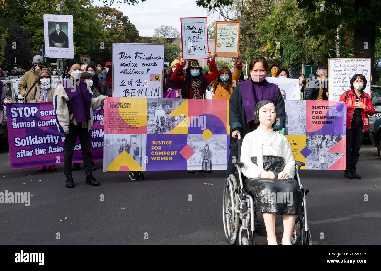 13. Oktober 2020, Berlin: Vertreter des Korea-Vereins protestieren bei einem demonstrationsmarsch von der Friedensstatue in Moabit zum Bezirksstadthauses gegen die Entfernung der Friedensstatue in Moabit. Ende September 2020 hatte der Deutsche Korea-Verband die Friedensstatue enthüllt. Die Friedensstatue erinnert nach Angaben des Vereins an die mehr als 200,000 Mädchen und Frauen aus 14 Ländern, die während des Asien-Pazifik-Krieges (1931-1945) im gesamten asiatisch-pazifischen Raum als sogenannte "Trostfrauen" vom japanischen Militär sexuell versklavt wurden. Die Friedensstatue in ist jetzt Stockfoto