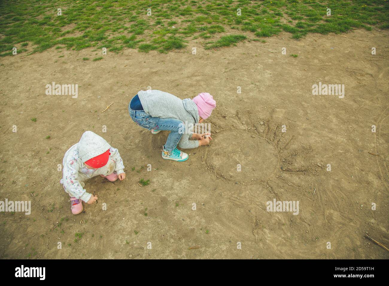 Zwei arme Kinder, die auf dem Boden spielen. Traurig verlassen Stockfoto