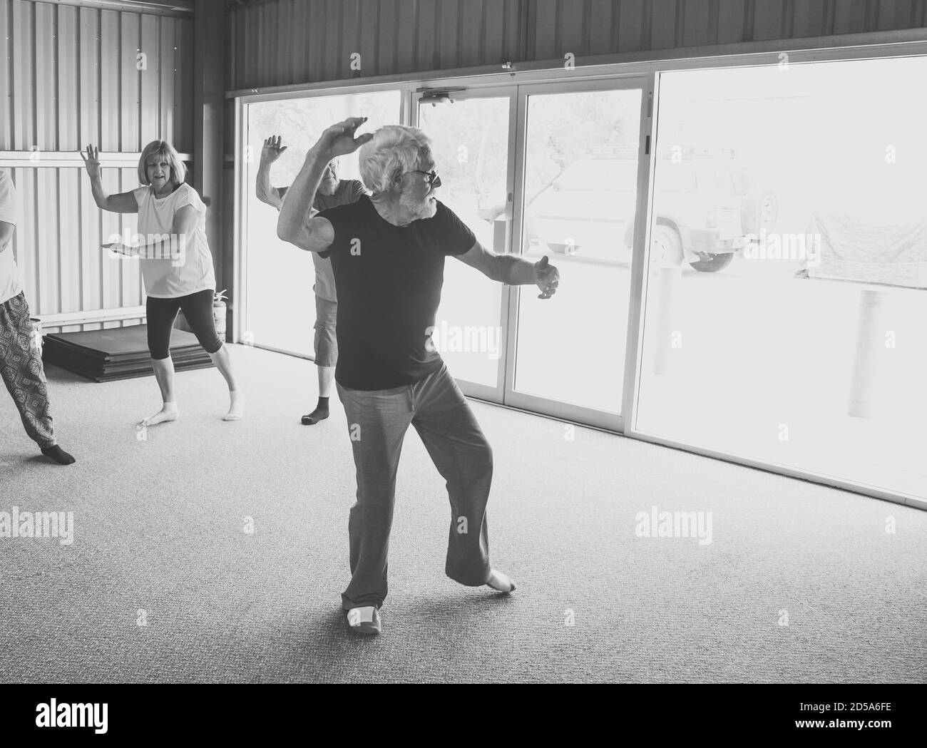 Gruppe von Senioren in Tai Chi Klasse Ausübung in einem aktiven Ruhestand Lebensstil. Psychische und körperliche Gesundheit Vorteile von Bewegung und Fitness bei älteren Menschen Stockfoto