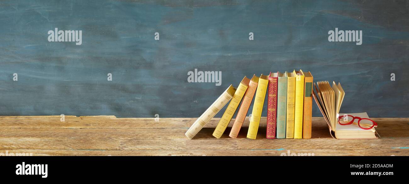 Buchreihe und offenes Buch. Lesen, Literatur, Bildung, Bibliothek, Home-Office-Konzept, Panorama große Kopiefläche Stockfoto
