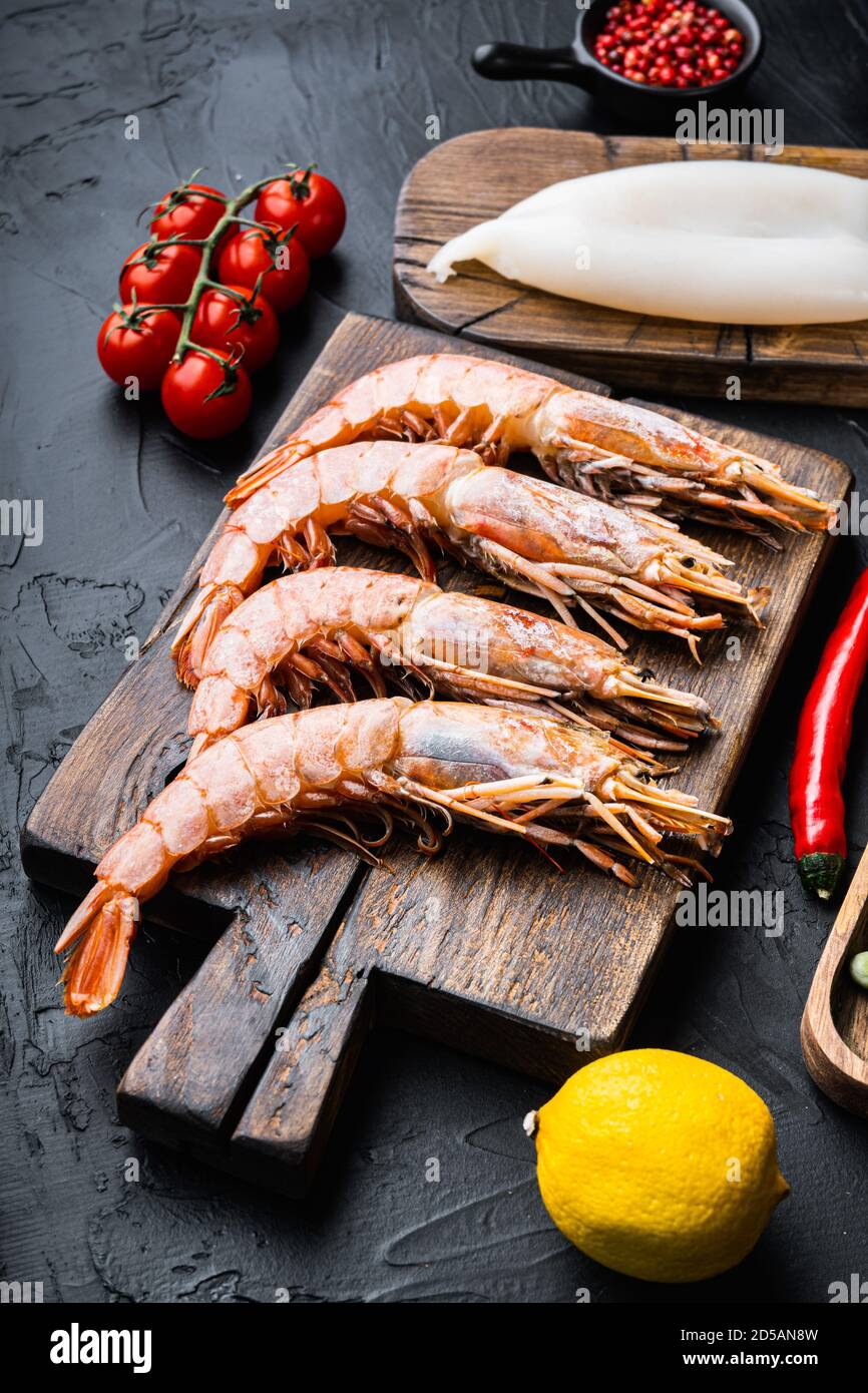 Set von Garnelen mit Zutaten für Paella auf schwarz Strukturierter Hintergrund Stockfoto