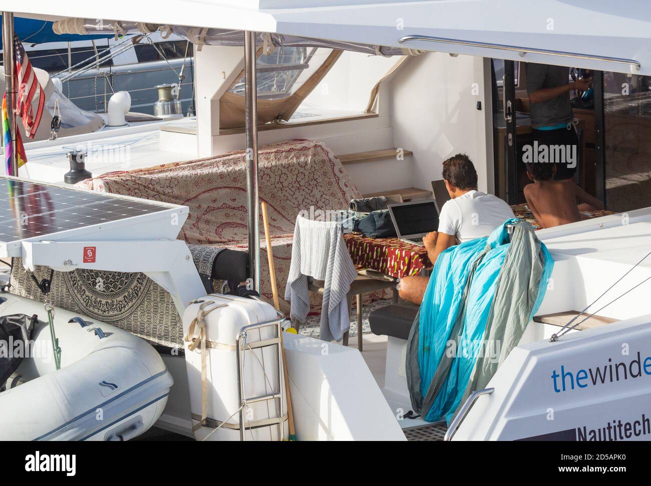 Mann, der auf dem Laptop auf Deck einer großen Yacht arbeitet Stockfoto
