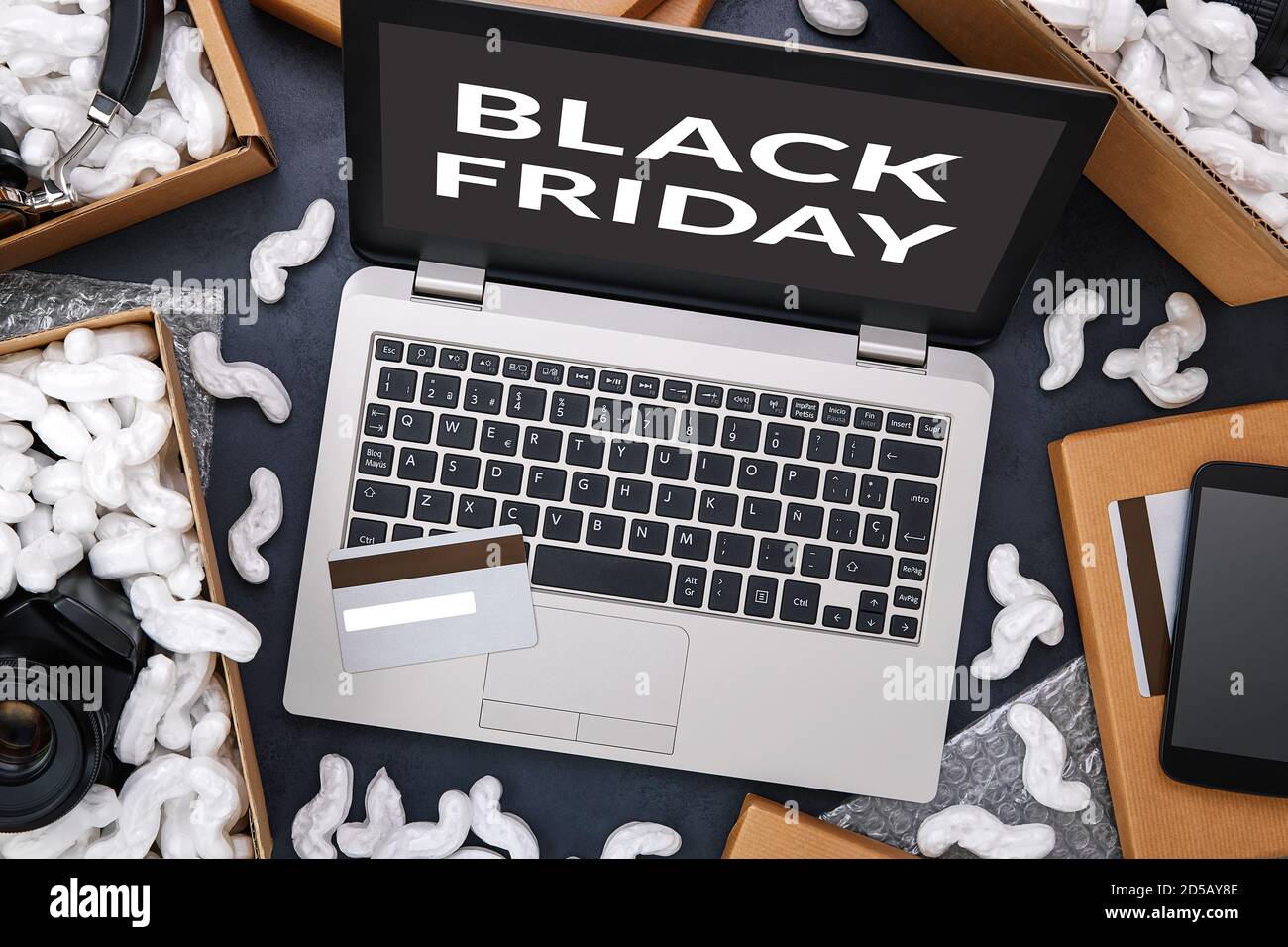 Black Friday und großer Verkauf in Elektronik-Shop-Konzept. Laptop und Kreditkarte, umgeben von Kartons mit Schaumstoffpolstern und Elektronik Stockfoto