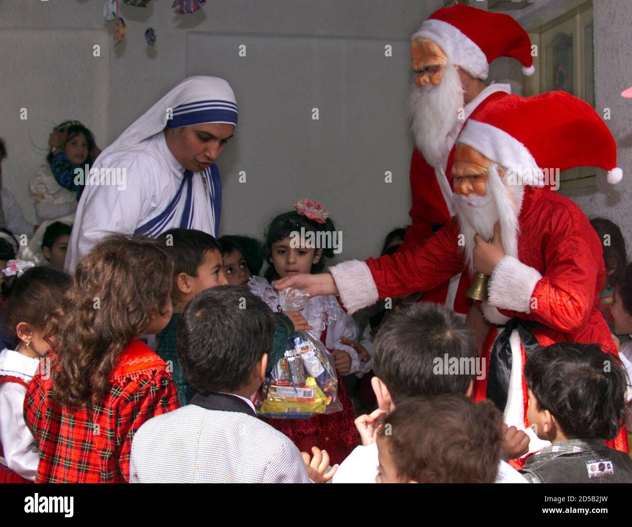 Palästinensische Nonnen und Weihnachtsmänner schenken palästinensischen  Kindern Geschenke, während sie Weihnachten in der Deir Al Lateen Kirche im  Gazastreifen feiern 22. Dezember. Der Gazastreifen hat eine Bevölkerung von  über einer Million ...