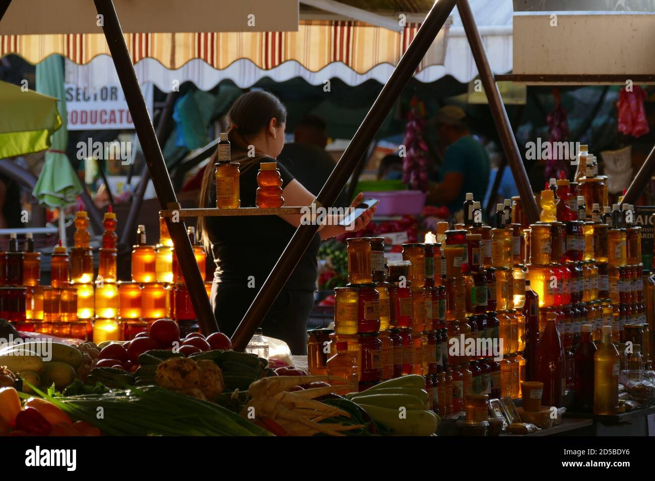 Die Sonne geht über einem Honigverkäufer-Stand in der siebenbürgischen Stadt Sibiu unter und bringt einen natürlichen goldenen Glanz in den Honig. Bild von Adam Alexander Stockfoto
