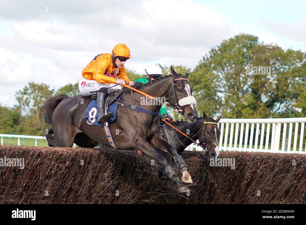 Brian Hughes reitet Champagne Noir (orange) und gewinnt die MansionBet stolz darauf, die Handicap Chase (GBB Race) (Div 2) von British Racing-Neulingen auf der Huntingdon Racecourse zu unterstützen. Stockfoto