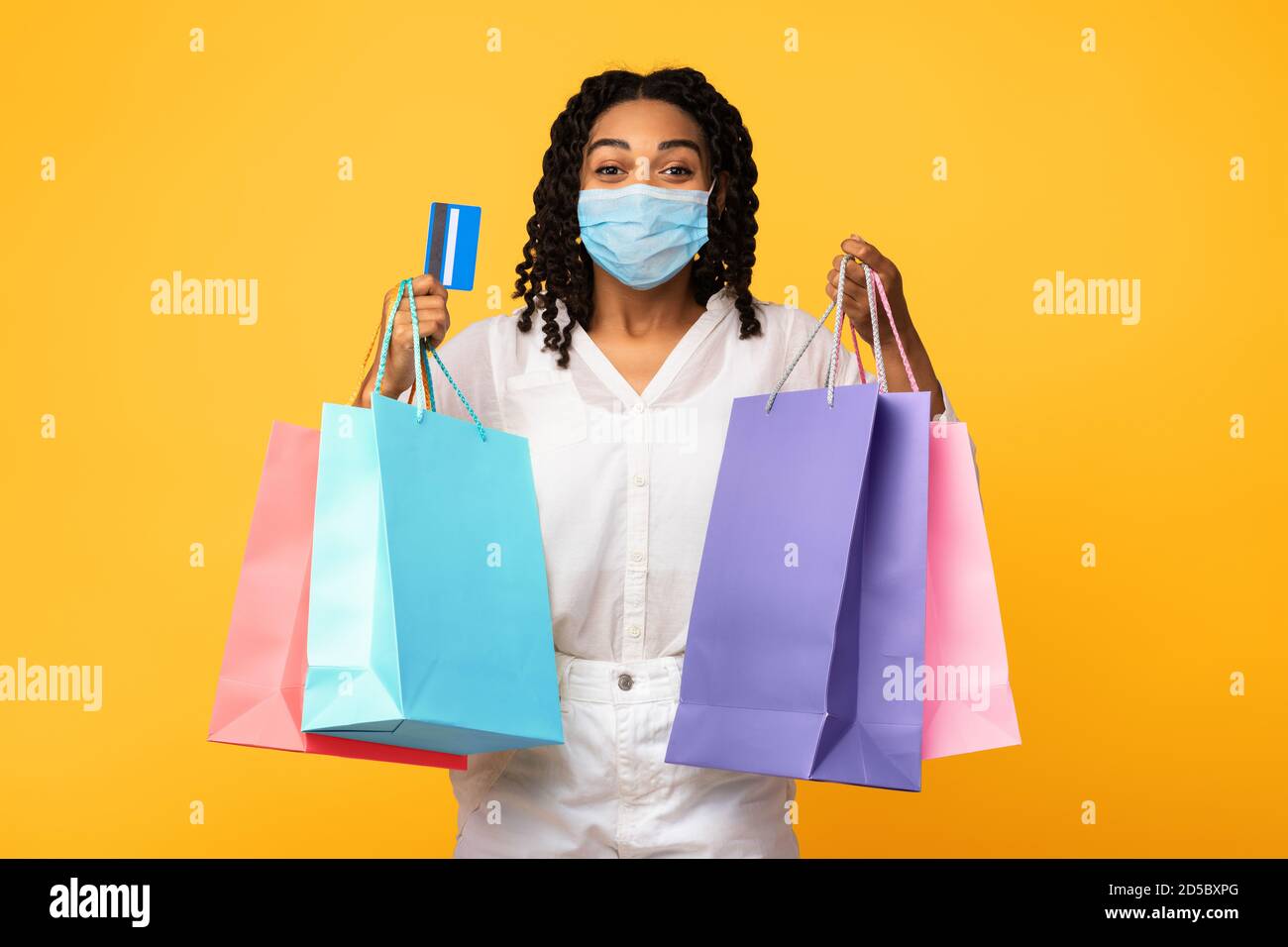 African Woman Shopping In Mask Holding Kreditkarte, Studio Shot Stockfoto