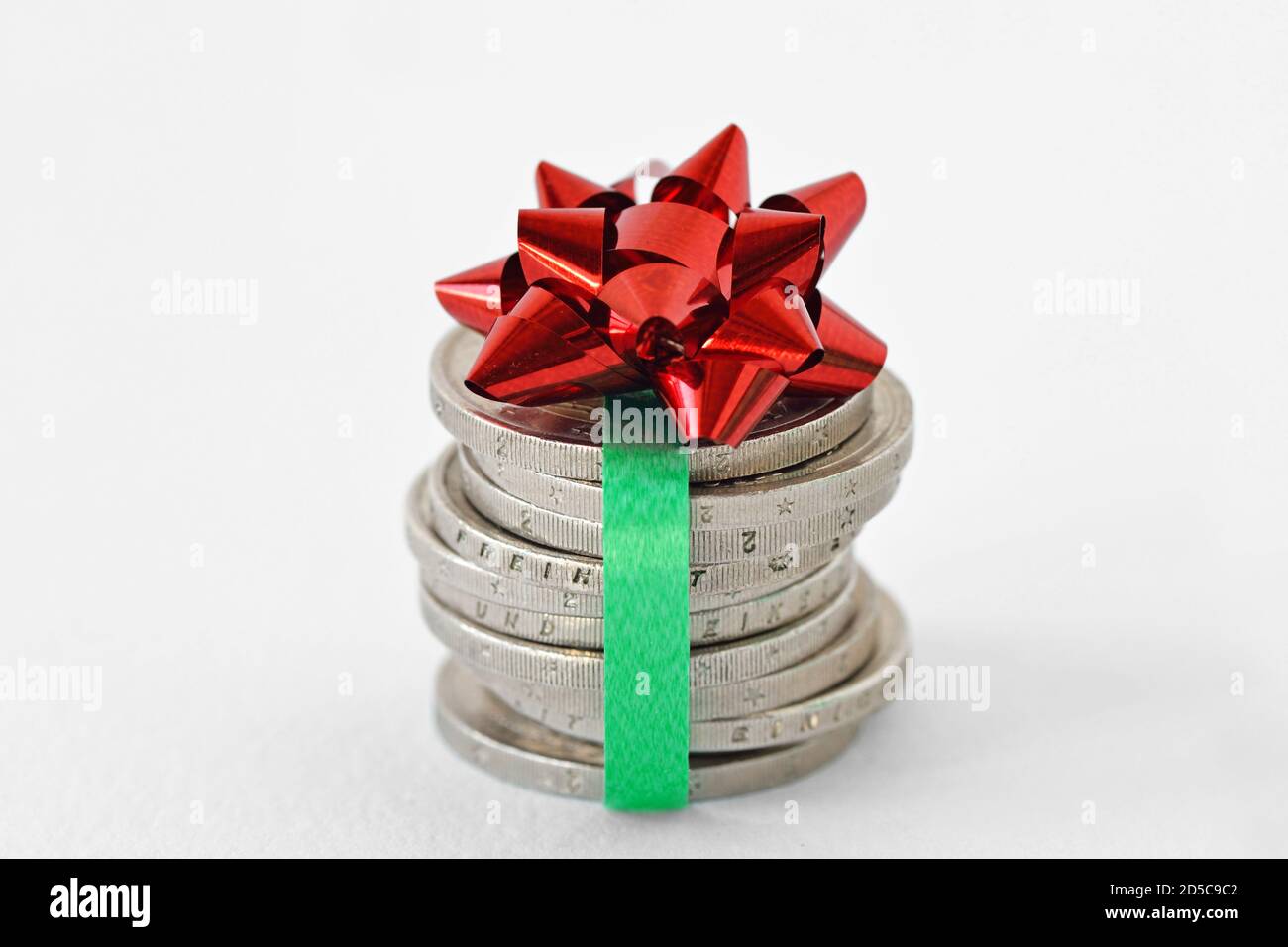 Stapel von Euro-Münzen mit Band und Geschenkschleife verpackt - Konzept der Wirtschaft und Geldgeschenk Stockfoto