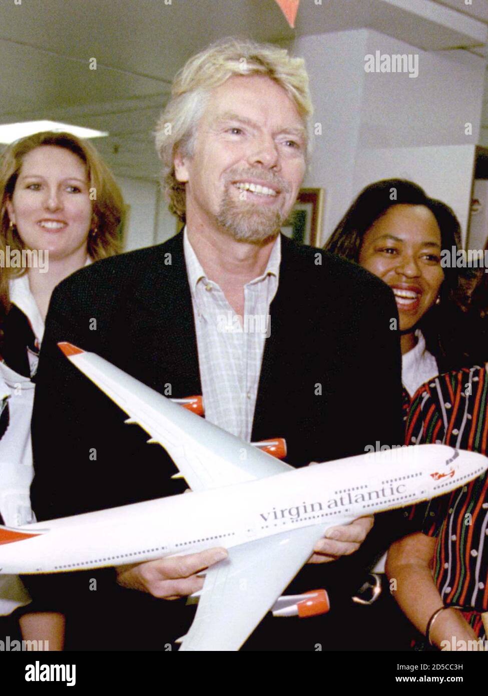 Britische Tycoon Richard Branson hält ein Modell eines Flugzeugs mit