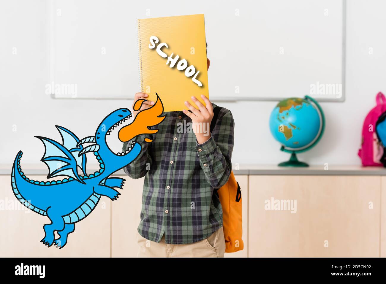 Schuljunge hält Buch in der Nähe Gesicht und Dinosaurier Illustration in der Schule Stockfoto