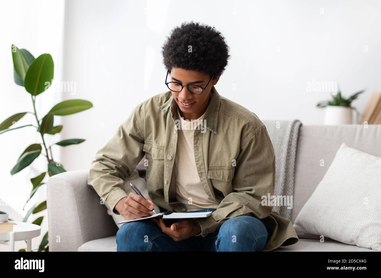 Fernunterricht. Afroamerikanische Teenager-Universitätsstudentin, die von zu Hause aus zu Zeiten der Sperre studiert Stockfoto