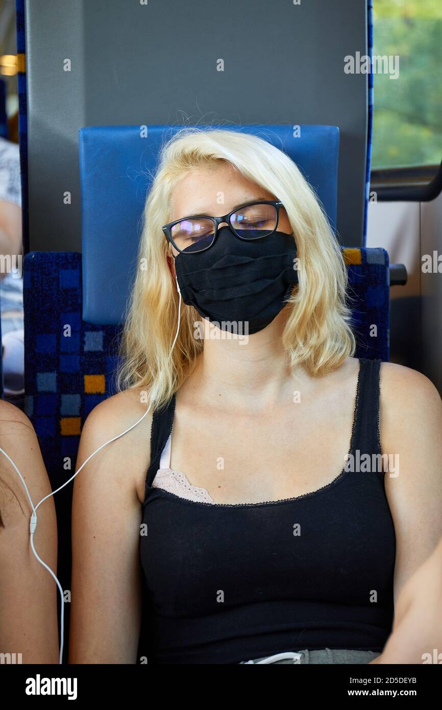 Junge Frau in einem Zug mit Masken Stockfoto