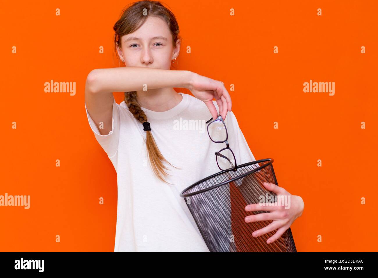 Close up lächelnd ruhig ernst junge Mädchen werfen sie weg Gläser im Mülleimer Stockfoto