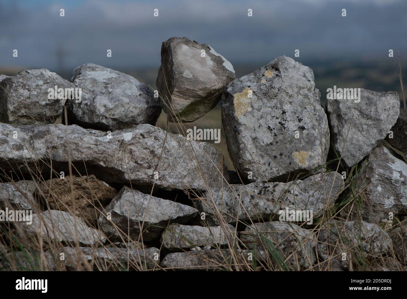 Nahaufnahme einer traditionellen Felswand aus trockenem Stein, die eine Farmers Field-Grenze trennt. Stockfoto