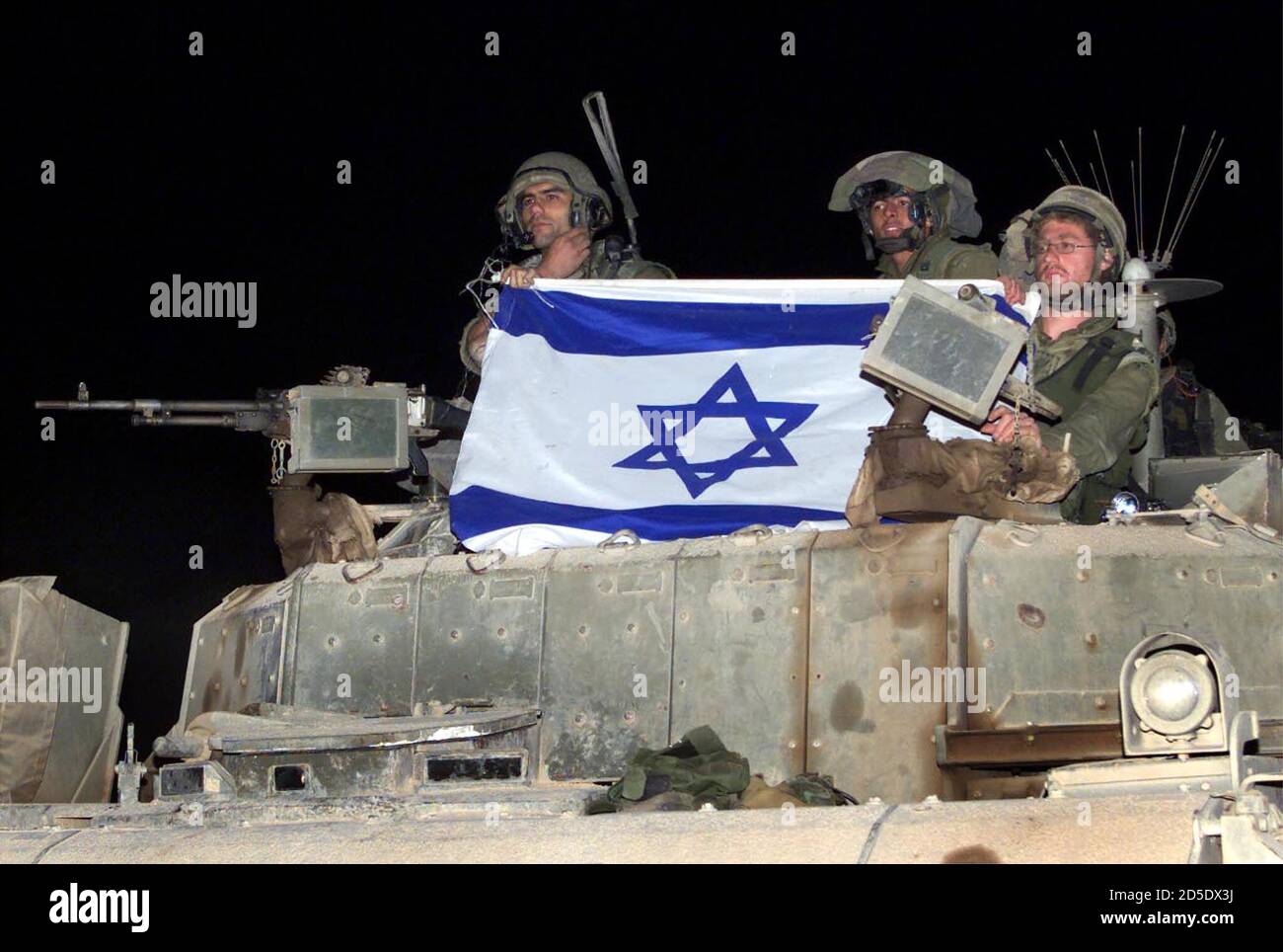 Israelische Soldaten an Bord eines großen Panzerpersonalträgers (APC) zeigen ihre Flagge, als sie den Südlibanon Anfang Mai 24 über ein Tor in Metullka verlassen. Es wird erwartet, dass der vollständige Rückzug der israelischen Armee aus zwei Jahrzehnten der Besetzung des Südlibanons durch erstes Licht abgeschlossen wird Heute. Stockfoto