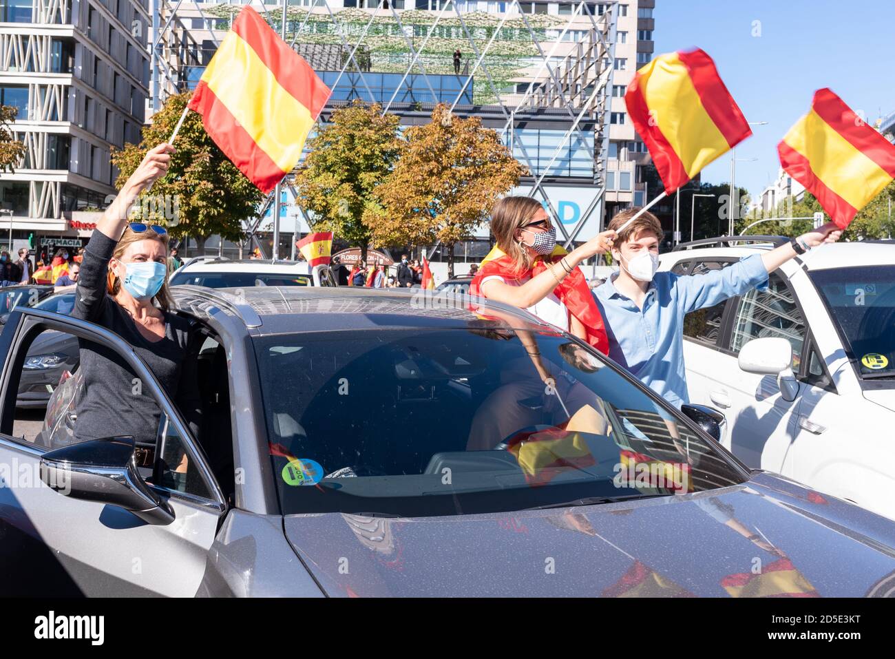 Madrid, Spanien, 12. oktober 2020. Menschen mit maskenschwingenden Fahnen, die an einem Protest gegen die Behandlung der COVID-19-Krise durch die spanische Regierung teilnehmen. Stockfoto