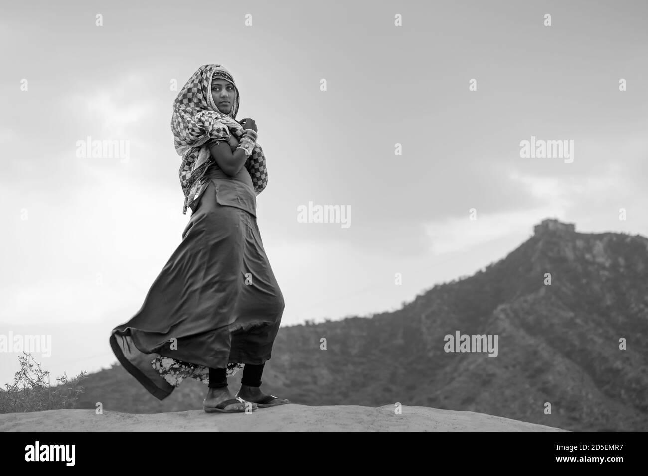 Junge Zigeunerin in traditioneller Kleidung, die einen Teil ihres Gesichts in der Thar-Wüste im Morgengrauen in Pushkar, Rajasthan, Indien bedeckt. Stockfoto