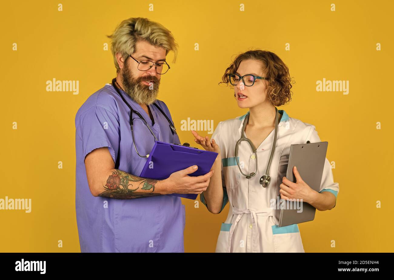 Check in mit Ihrer Gesundheit. Vertrauen Sie unseren Fachleuten. Healthcare Business. Teamwork und Menschen Konzept. Arzt und Krankenschwester. Erfolgreiches Team von Ärzten. Menschen in Uniformen gelben Hintergrund. Stockfoto