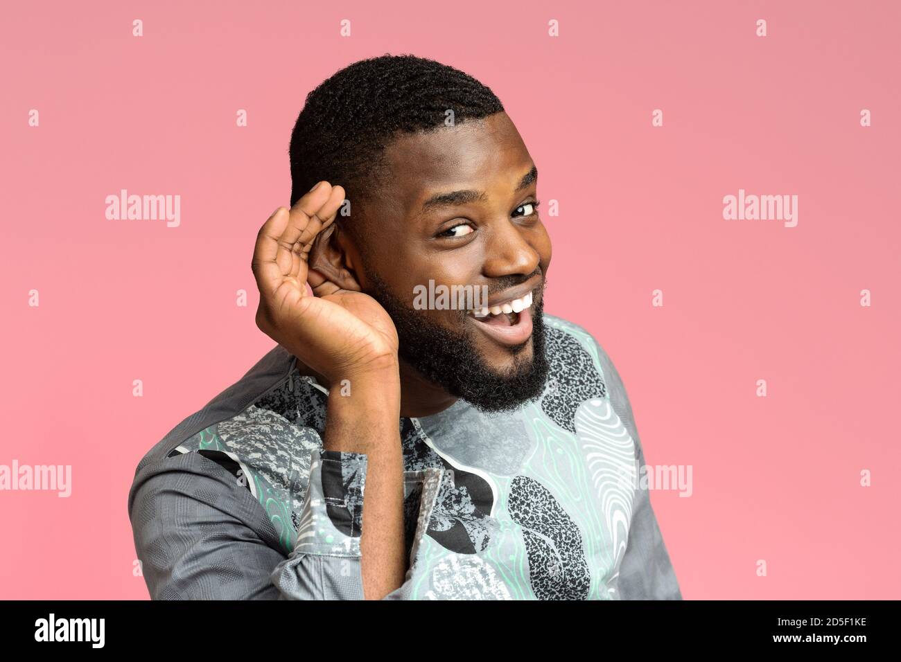 Neugieriger afroamerikanischer Mann, der die Hand am Ohr hält Stockfoto