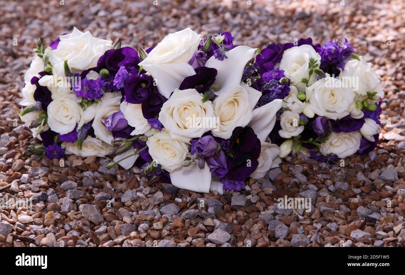 Weiße Rosen und lila Blüten in drei Hochzeitssträußen Stockfoto