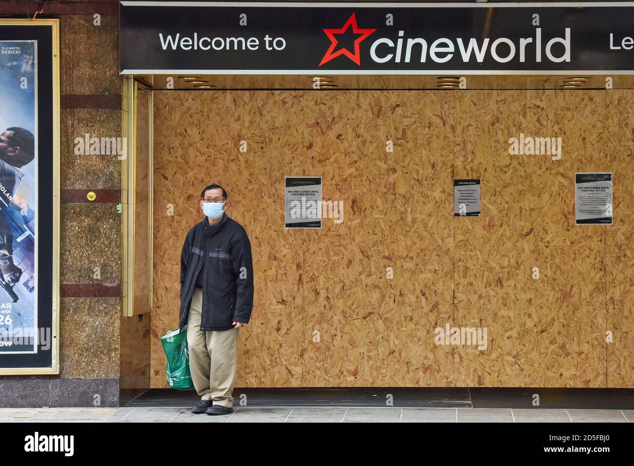 Ein Mann mit Gesichtsmaske steht vor dem Cineworld Kino in London.die britische Kinokette Cineworld kündigte an, dass sie vorübergehend Kinos in Großbritannien und den Vereinigten Staaten schließt, da die Coronavirus-Pandemie große neue Filme verzögert. Stockfoto