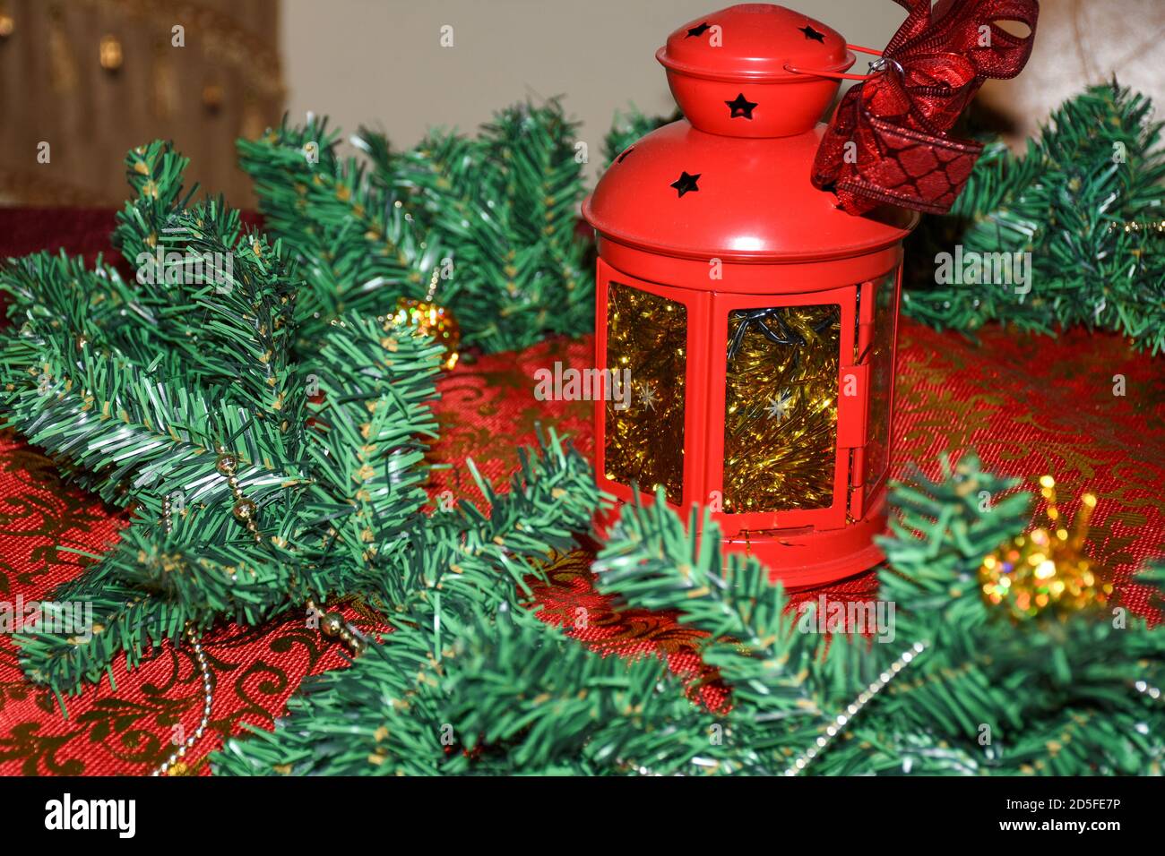 Weihnachtskranz auf rotem Tischtuch und Laterne Kerzenhalter für Urlaubskonzepte und -Themen. Stockfoto