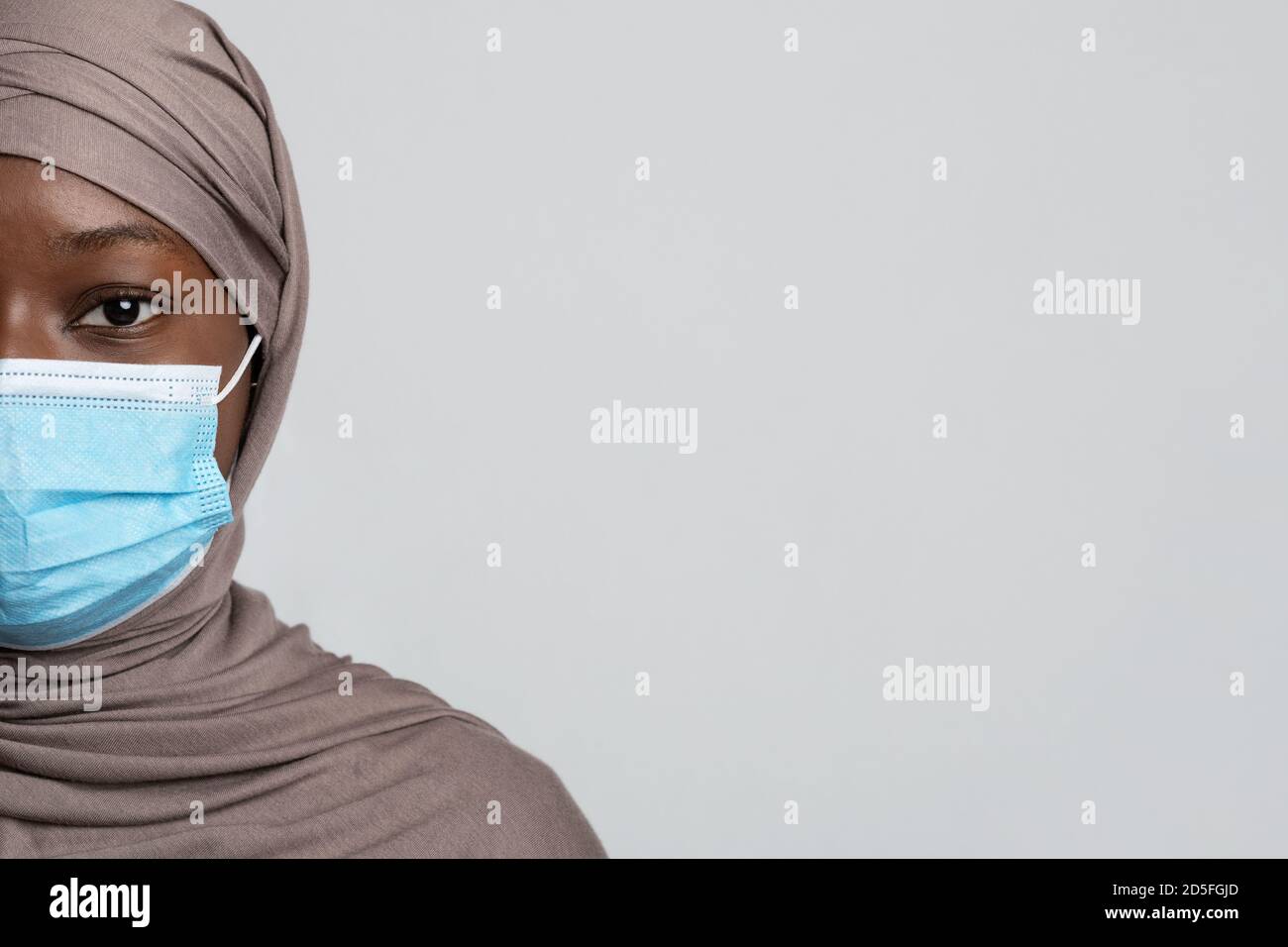 Halbgesicht Porträt Der Schwarzen Muslimischen Lady In Hijab Und Medizinische Maske Stockfoto