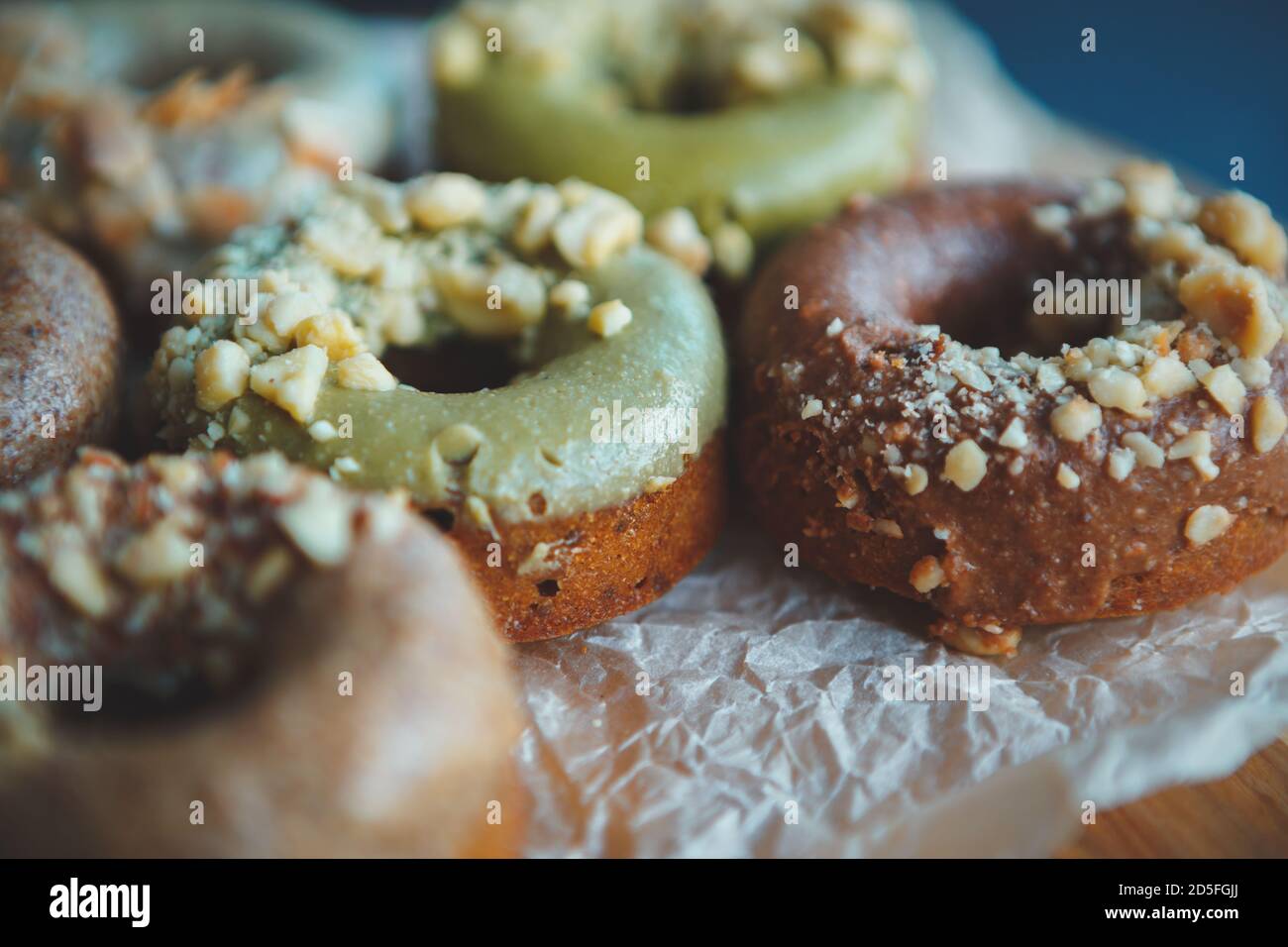 Donuts zum Mittagessen.Donuts in Bäckerei Café für Frühstück Mahlzeit.Gebäck vorbereitet Produkte mit Pistazien Glasur & Nüsse.köstliche süße Dessert Essen gebacken ich Stockfoto