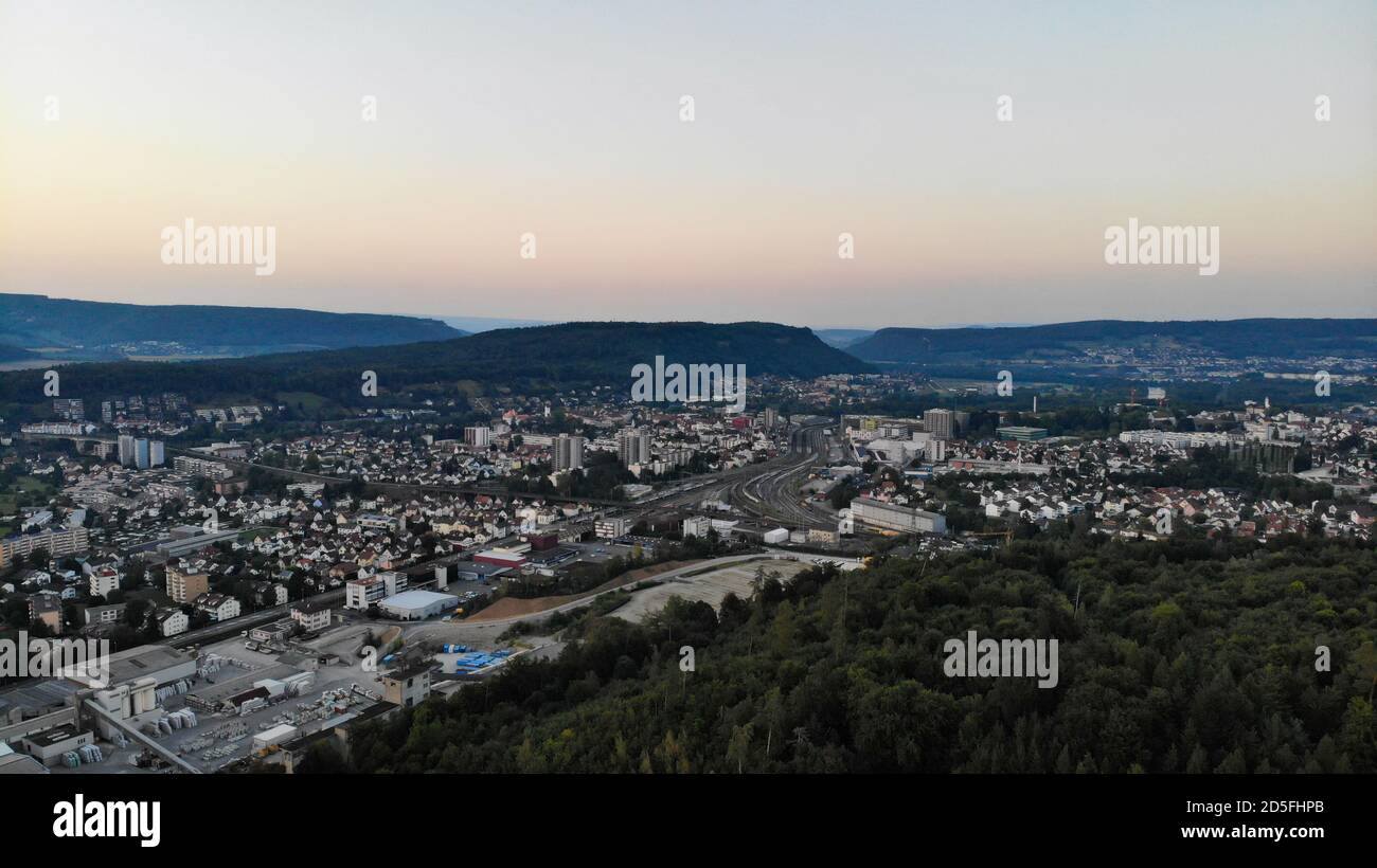 Luftaufnahme über Brugg nach Sonnenuntergang. Industrie, Bahnhof und Wohngebiet von Brugg, einem Dorf im Kanton aargau. Vom Habsburger Wald aus gesehen. Gewinnen Stockfoto