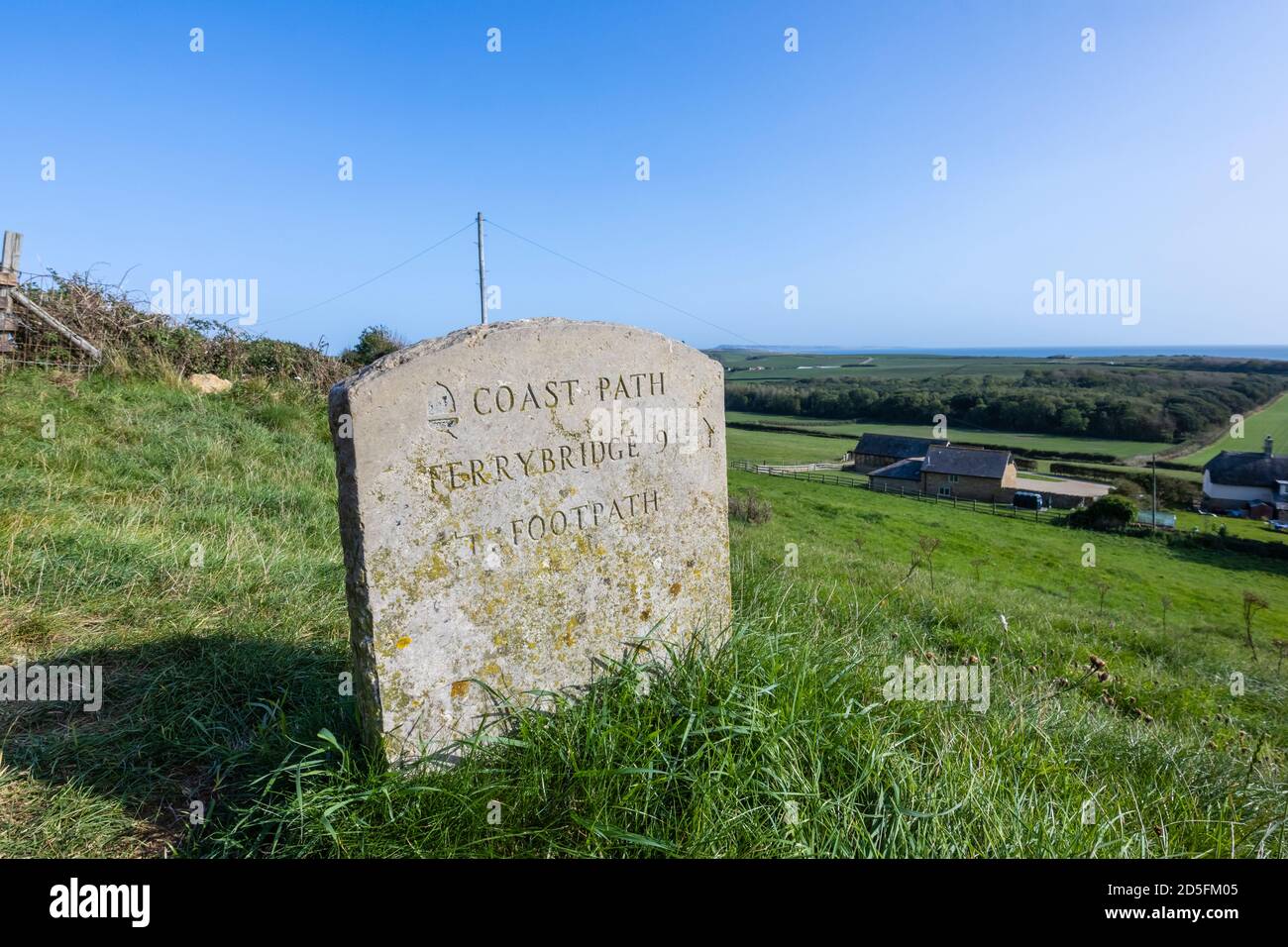 Steinwegmarkierung, die auf Ferrybridge zeigt, das auf einem Feld auf dem South-West Coast Path an der Heritage Coast, Abbotsbury, Dorset, liegt Stockfoto