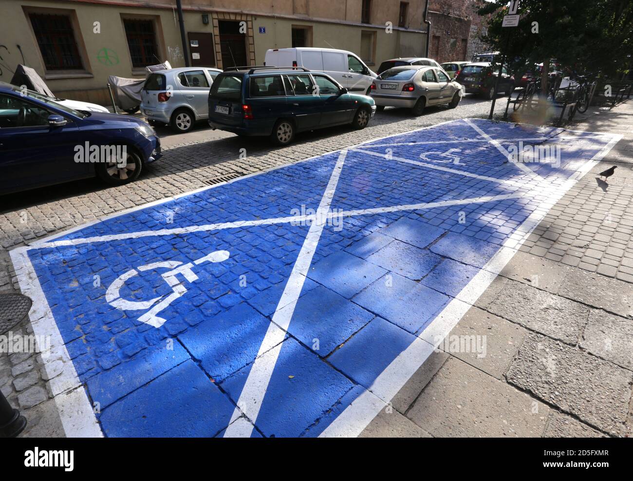 Krakau. Krakau. Polen. Leerer blauer Parkplatz für Behinderte, Rollstuhlsymbol. Blick auf die Straße. Stockfoto