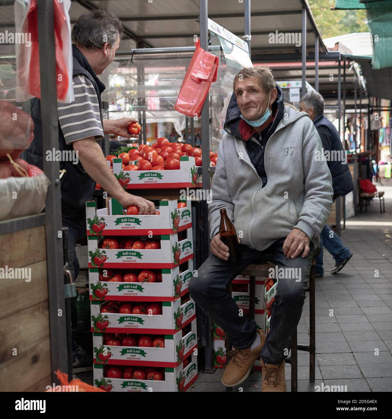 Belgrad, Serbien, 11. Oktober 2020: Ein Stallholder trinkt Bier aus einer Flasche auf dem Bauernmarkt Stockfoto