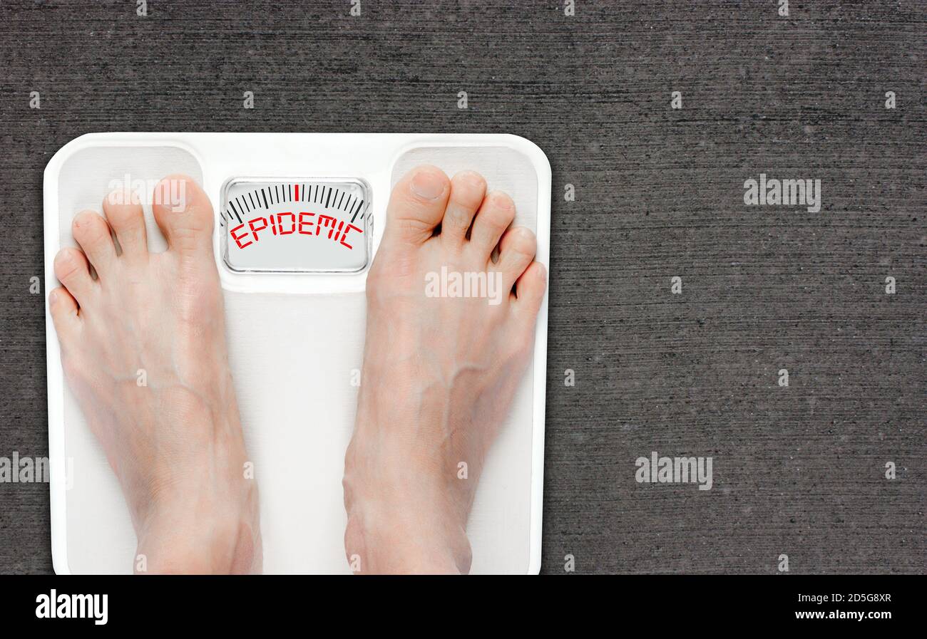 Füße auf Badwaage mit dem Wort EPIDEMIE auf dem Bildschirm. Adipositas hat weltweit epidemische Ausmaße erreicht, mit mehr als 1 Milliarde Erwachsenen übergewichtig Stockfoto