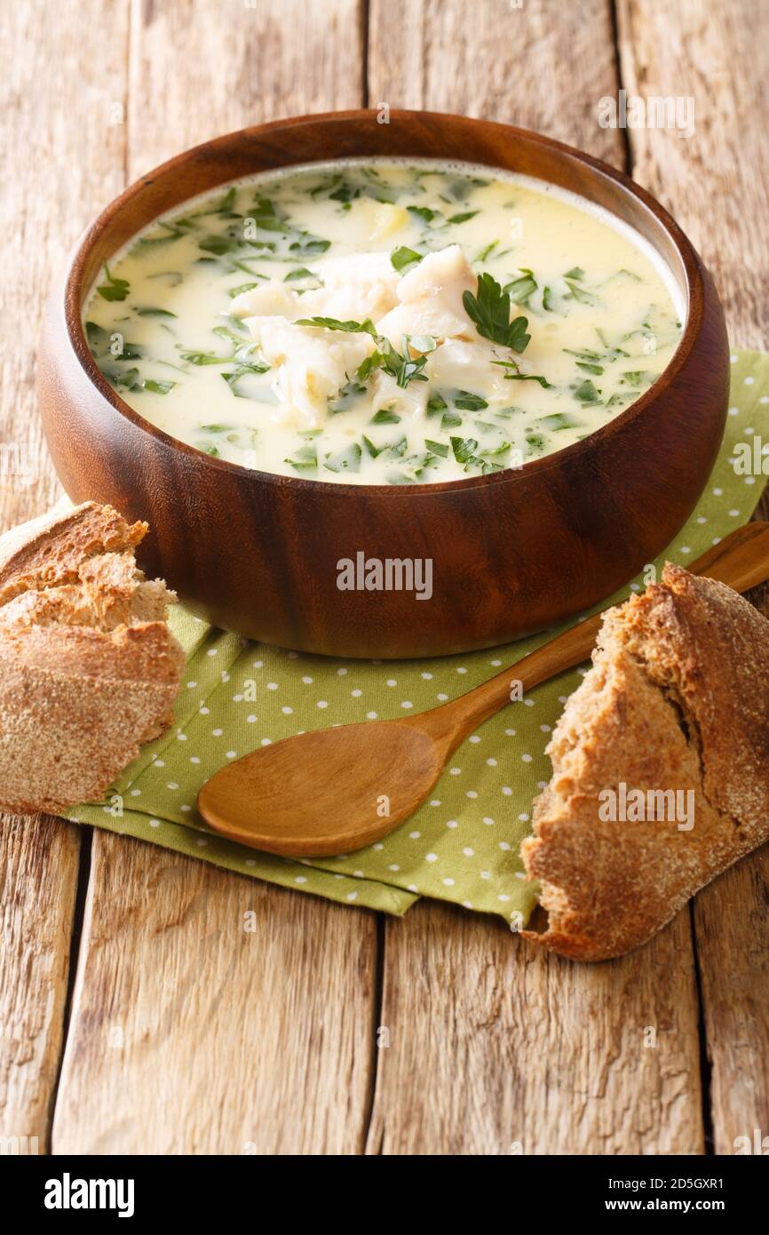 Tasty Cullen Skink ist eine klassische schottische geräucherte Fischsuppe mit samtigem Lauch und Kartoffel-Nahaufnahme auf dem Teller auf dem Tisch. Vertikal Stockfoto