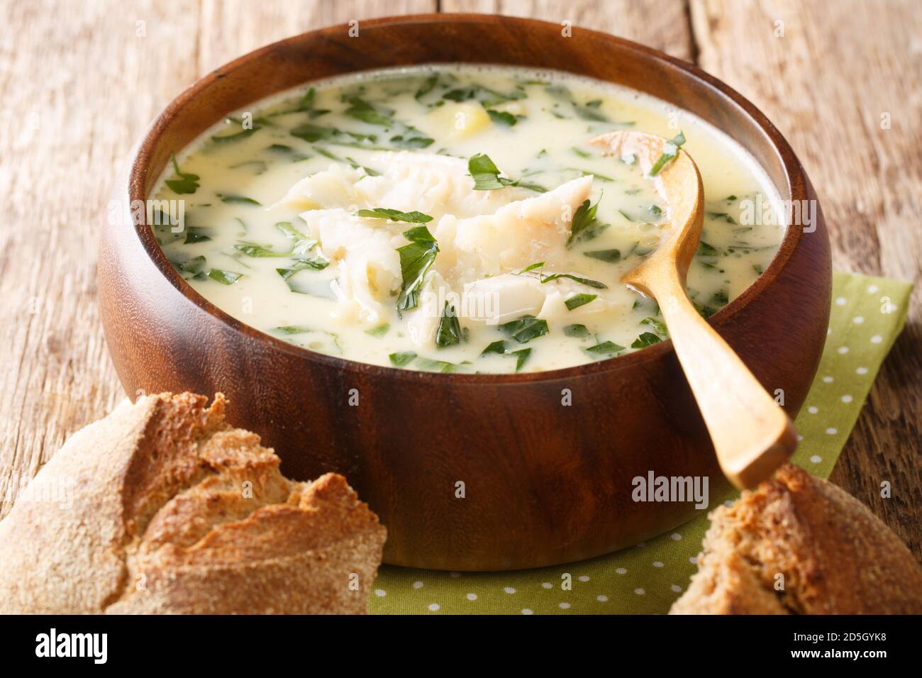 Cullen skink ist eine dicke schottische Suppe aus geräuchertem Schellfisch, Kartoffeln und Zwiebeln, die in der Nähe auf dem Teller auf dem Tisch liegen. Horizontal Stockfoto