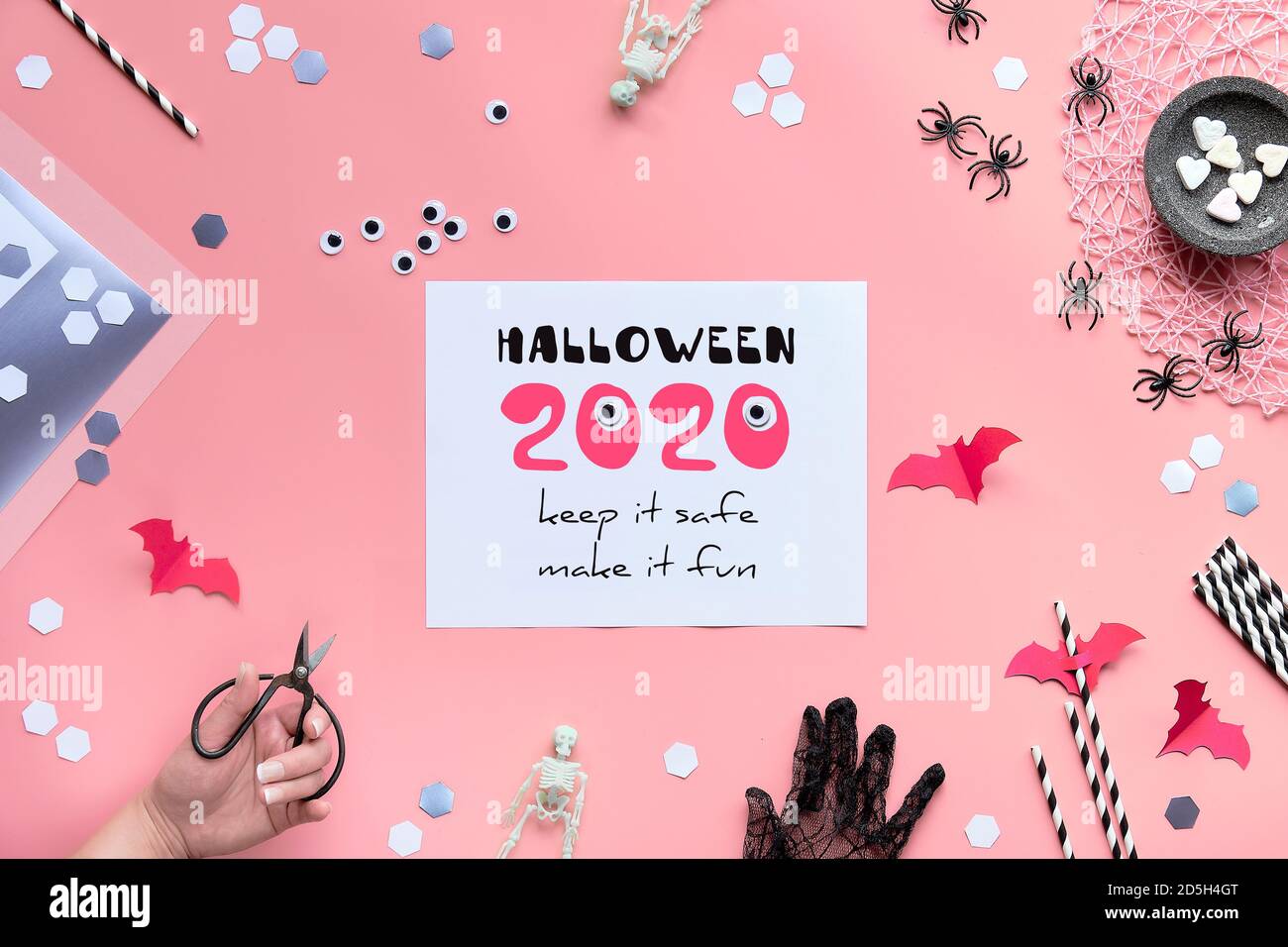 Rosa Papier Hintergrund mit Halloween-Dekor. Halloween 2020 Keep it Safe, machen es Spaß Text auf Papier. Stockfoto