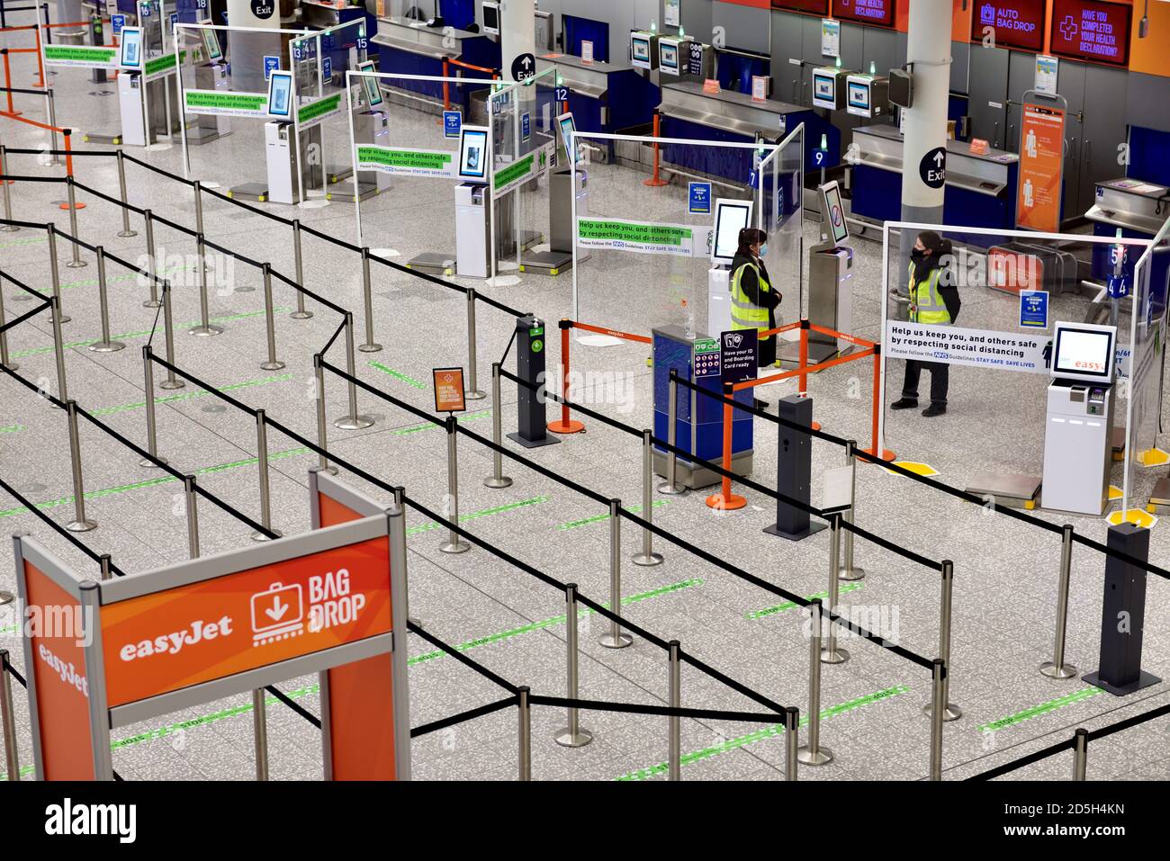 Leere Abflüge am Flughafen mit sozialer Distanz, Personal, aber keine Passagiere Stockfoto