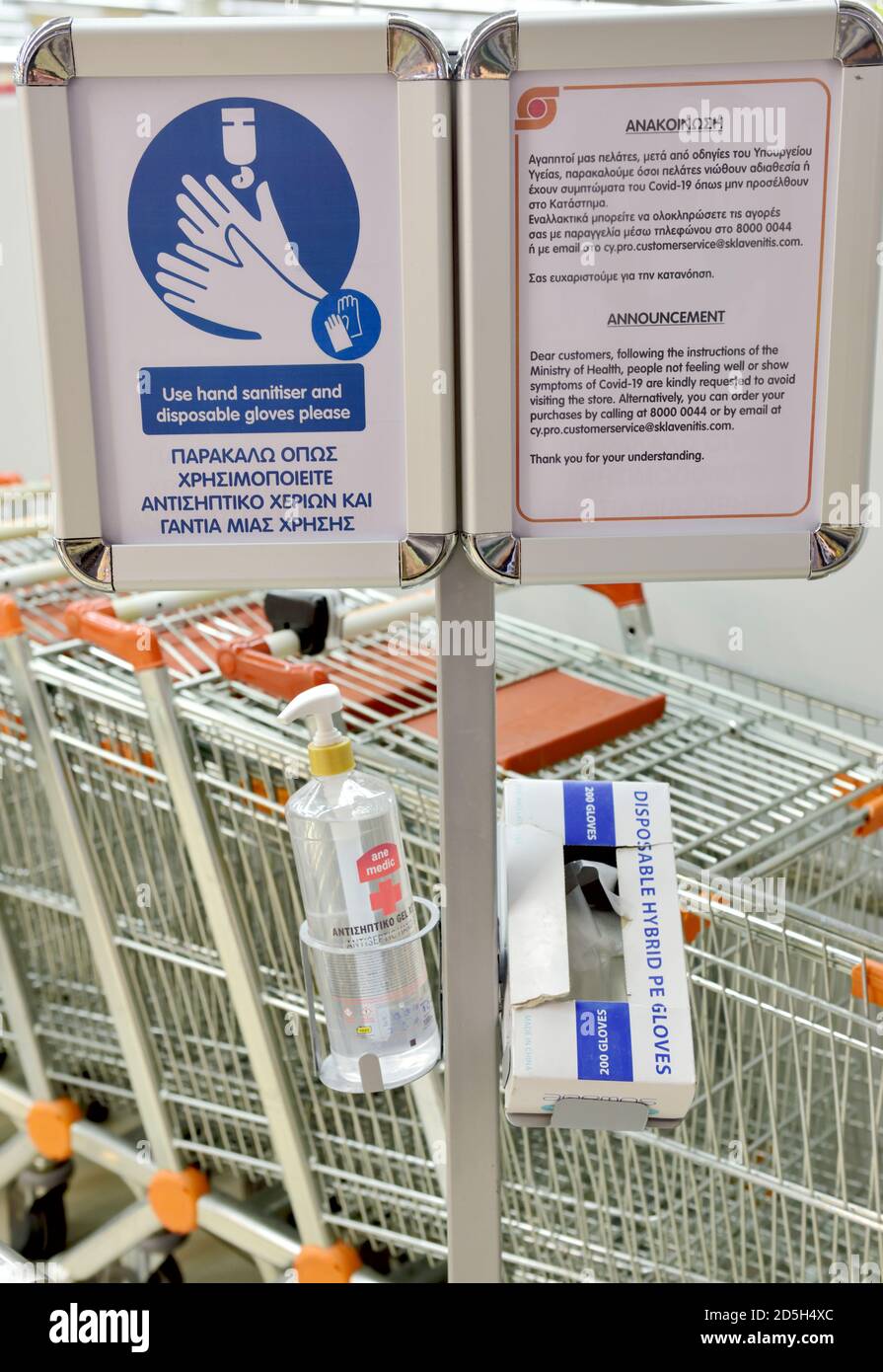 Händedesinfektionsmittel im Spender mit einer Schachtel mit Einweg-Plastikhandschuhen Und Zeichen sagen, sie zu verwenden Stockfoto
