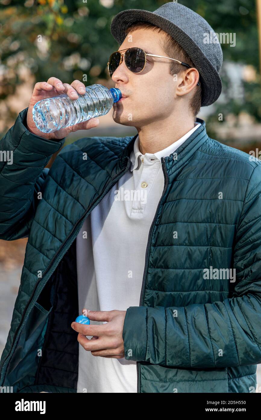Nahaufnahme von einem Mann Wasser aus einer Flasche außerhalb Stockfoto