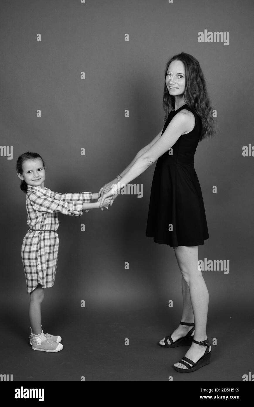 Mutter und Tochter kleben zusammen gegen grauer Hintergrund Stockfoto