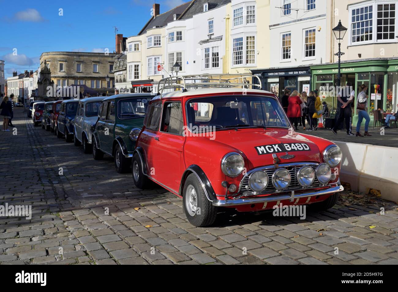 Ein Blick auf einen Doppelmotor 1965 Austin Mini Copper S mit anderen Minis, die am Wells Market Square geparkt sind Stockfoto