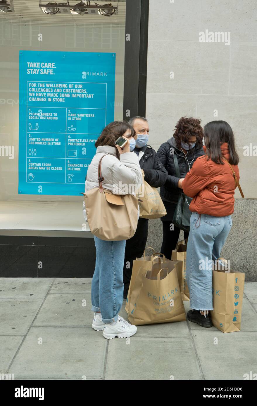 Einkäufer in der Oxford Street, mit Schildern, die darauf hinweisen, dass sie aufgrund der Coronavirus-/Covid-19-Pandemie in London, England, Großbritannien, einen sicheren sozialen Abstand halten sollten Stockfoto