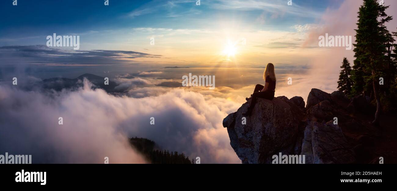 Hikerin auf einem von Wolken bedeckten Berg Stockfoto